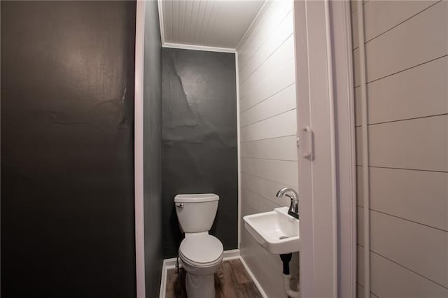 bathroom with crown molding, toilet, sink, and hardwood / wood-style flooring