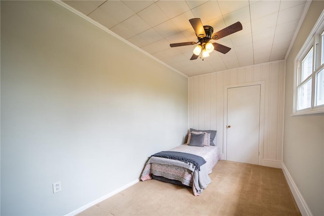 bedroom featuring ceiling fan, crown molding, and carpet