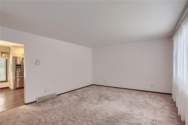 carpeted empty room featuring a wealth of natural light