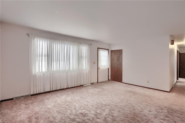 unfurnished room featuring light carpet