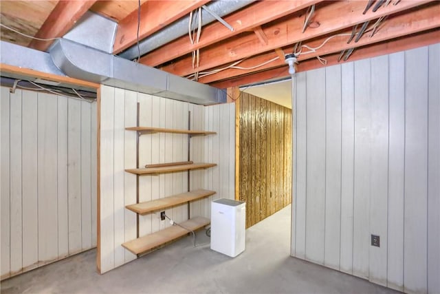 basement featuring wooden walls