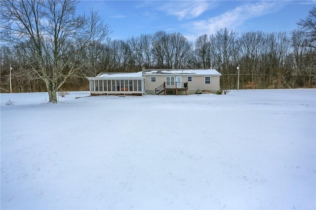 snow covered house with a sunroom