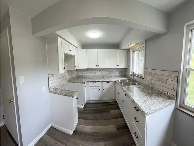 kitchen with tasteful backsplash, sink, white cabinets, and dark wood-type flooring