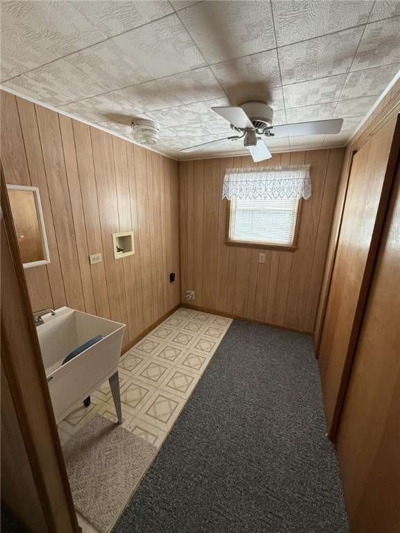 empty room featuring ceiling fan and wooden walls