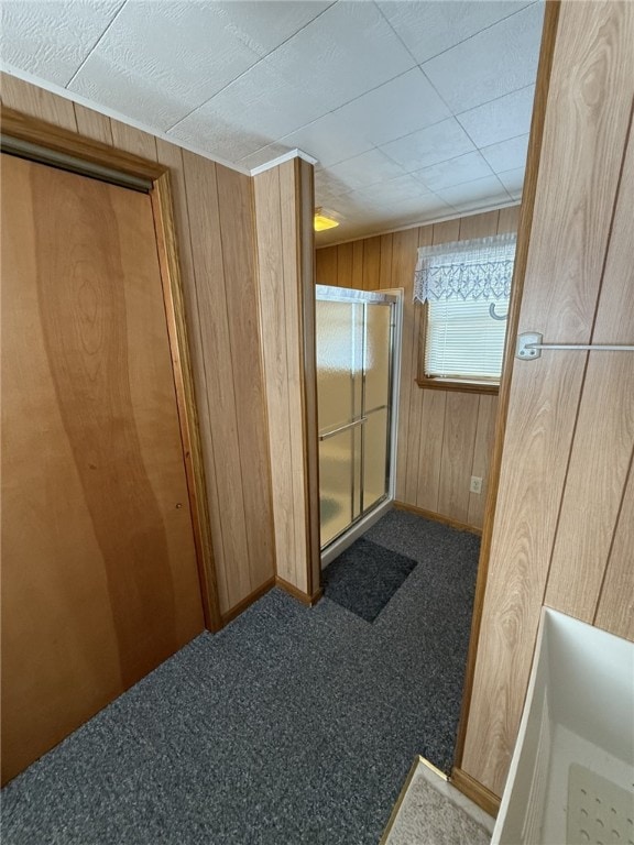 hall with carpet flooring and wood walls