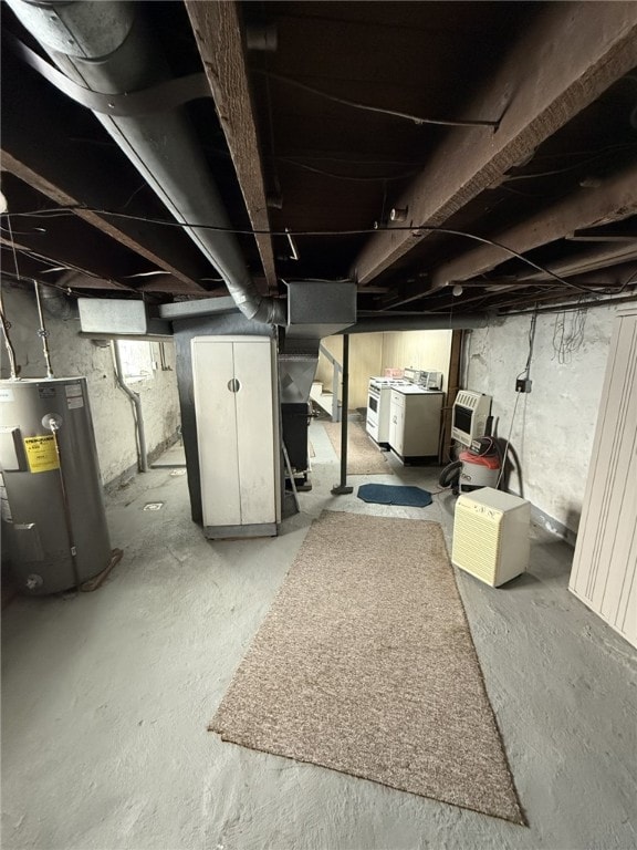 basement featuring heating unit, electric water heater, and washer and dryer