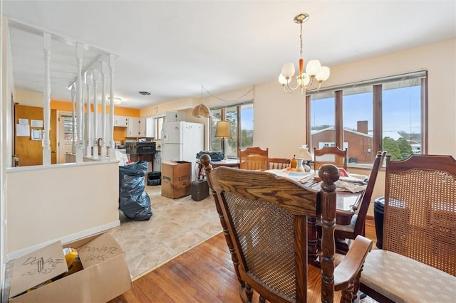 dining space with a notable chandelier and light hardwood / wood-style flooring