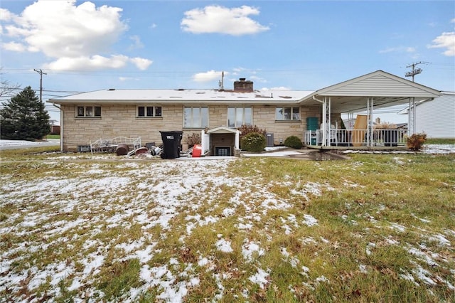 snow covered house with covered porch and central AC