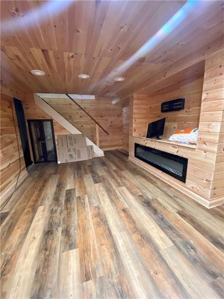 additional living space with wood-type flooring, wooden walls, and wood ceiling