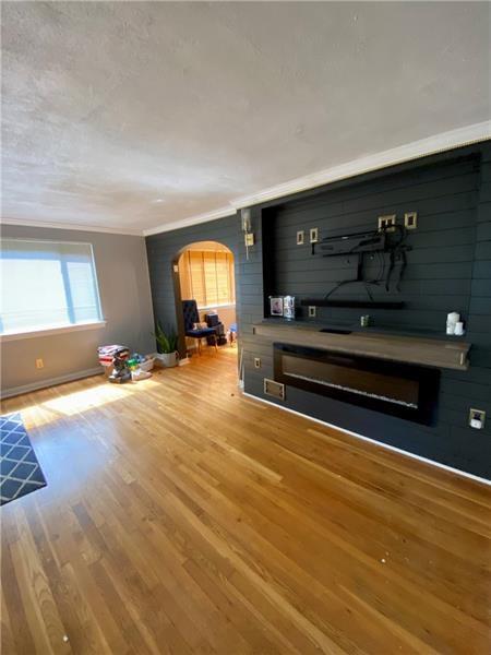 living room featuring wood-type flooring and ornamental molding