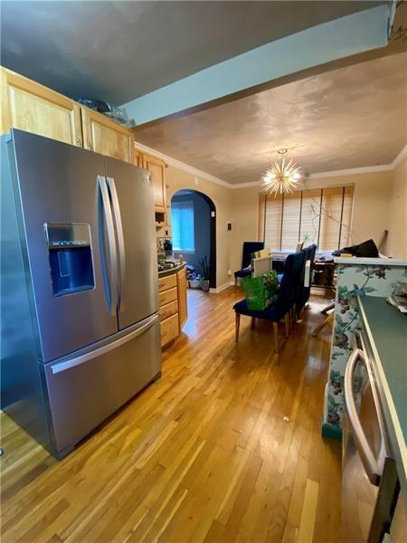 kitchen with light brown cabinets, hanging light fixtures, a notable chandelier, light hardwood / wood-style floors, and stainless steel fridge with ice dispenser