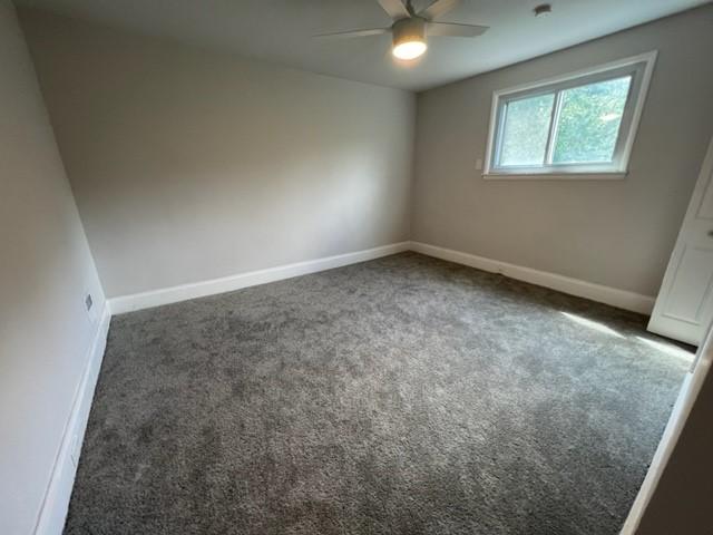 carpeted spare room with ceiling fan