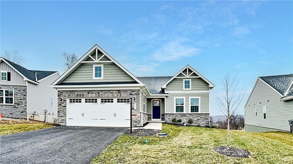 craftsman house with a front lawn and a garage