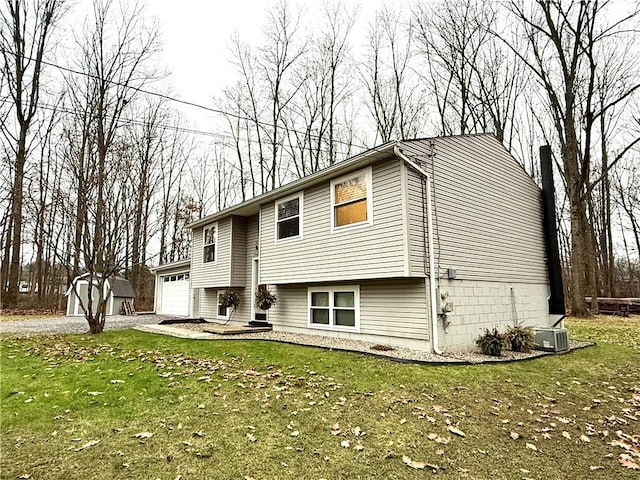 view of front facade with a front yard, a shed, a garage, and central AC unit