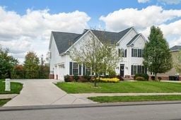 colonial home with a garage and a front yard