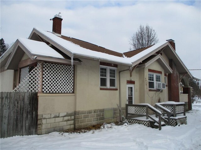 snow covered property with cooling unit