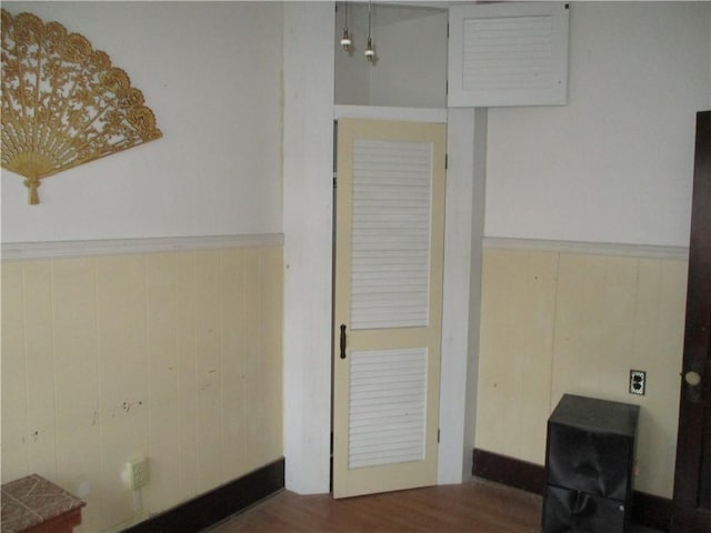 corridor with dark hardwood / wood-style flooring and wood walls