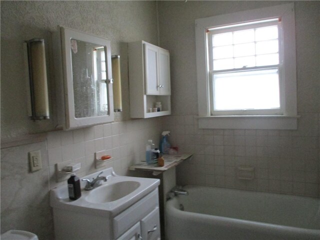 bathroom featuring a bath, vanity, and backsplash