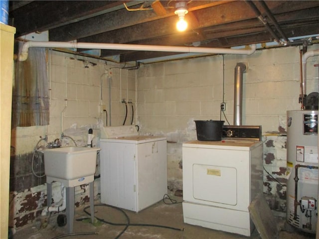 washroom with gas water heater, separate washer and dryer, and sink