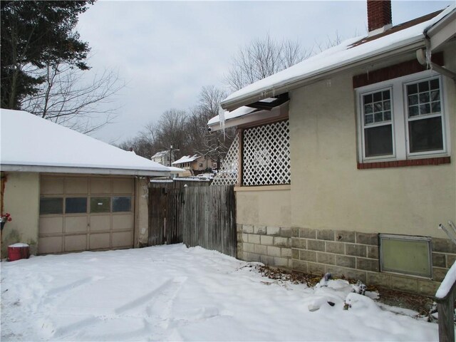 view of snowy exterior featuring a garage