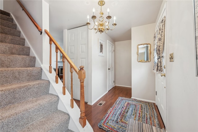 foyer entrance with dark wood-type flooring and a notable chandelier