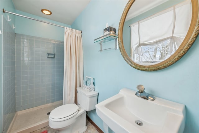 bathroom featuring curtained shower, sink, and toilet