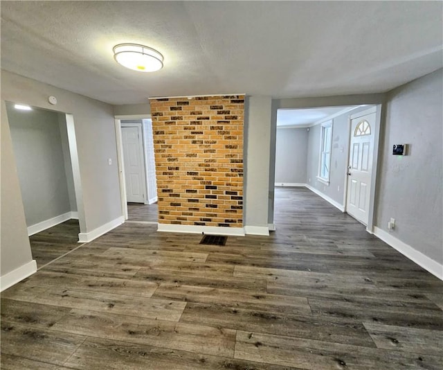 spare room with a textured ceiling and dark hardwood / wood-style floors