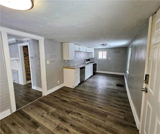 kitchen with white cabinetry, dark wood-type flooring, dishwasher, and light countertops