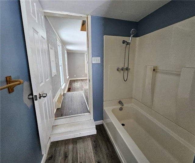 bathroom with bathtub / shower combination, baseboards, and wood finished floors