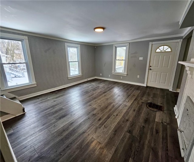 foyer entrance with a healthy amount of sunlight, dark hardwood / wood-style flooring, and crown molding