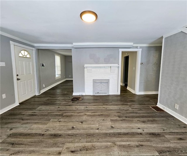 unfurnished living room featuring a brick fireplace, wood finished floors, and baseboards