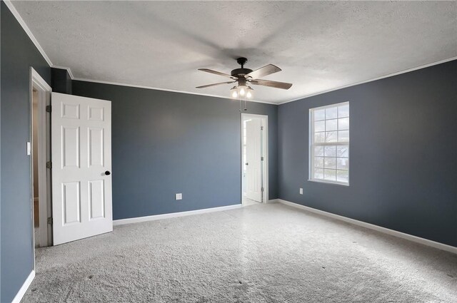 unfurnished room featuring carpet flooring, a textured ceiling, ceiling fan, and ornamental molding