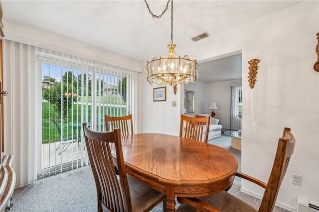 carpeted dining space with a chandelier and a baseboard radiator