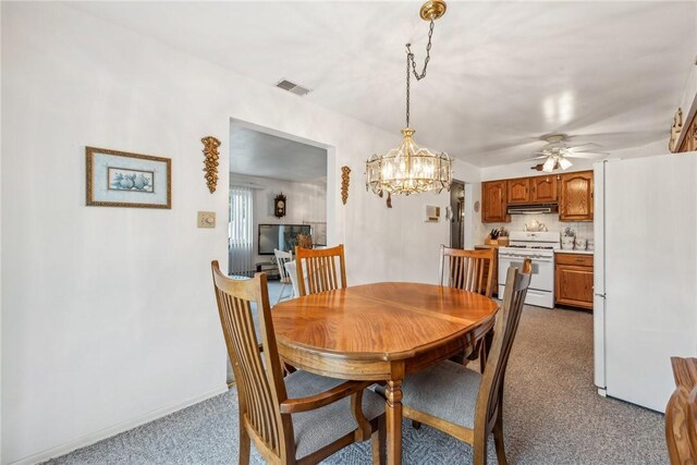 dining area with ceiling fan with notable chandelier and dark carpet