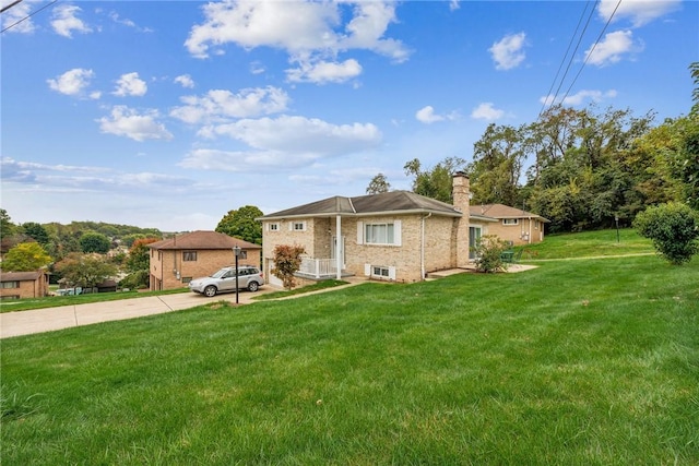 view of front of property with brick siding, a chimney, and a front lawn