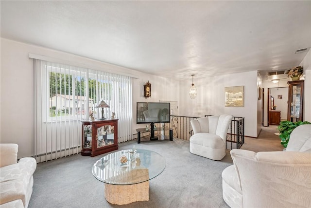 carpeted living room with an inviting chandelier and a baseboard heating unit