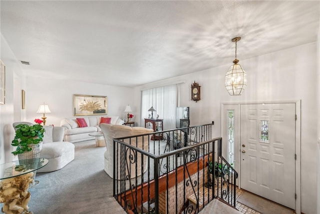 carpeted foyer entrance featuring a chandelier