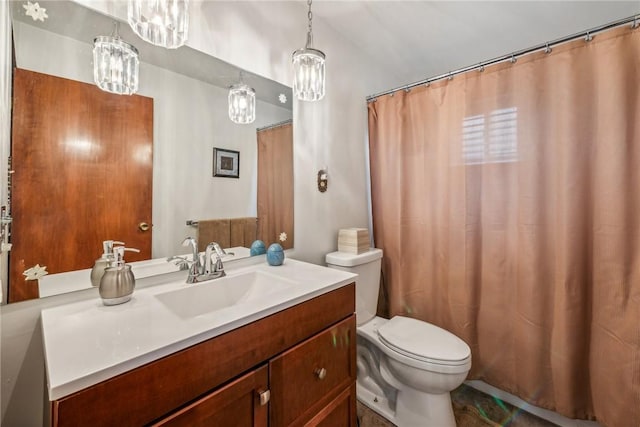 bathroom with toilet, vanity, and an inviting chandelier