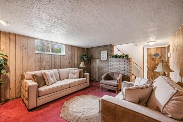 living room with a textured ceiling, dark carpet, and wood walls