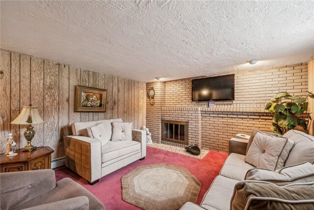 living room featuring wooden walls, carpet flooring, a textured ceiling, baseboard heating, and a fireplace