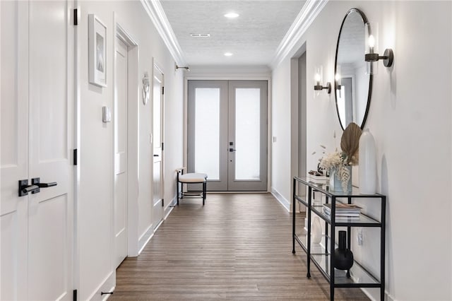 interior space with plenty of natural light, ornamental molding, a textured ceiling, and french doors