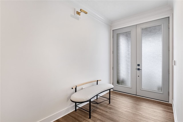 foyer entrance with wood-type flooring, crown molding, and french doors