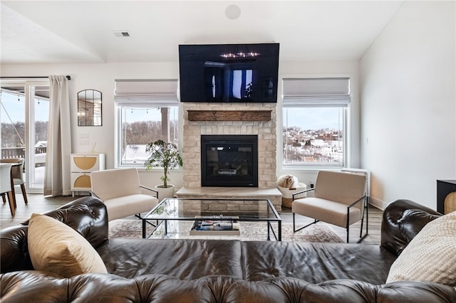 living room featuring a fireplace, hardwood / wood-style floors, and vaulted ceiling