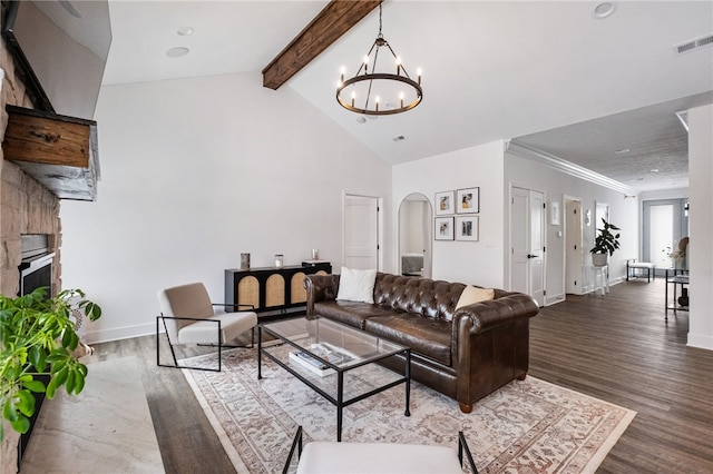 living room with vaulted ceiling with beams, a notable chandelier, dark hardwood / wood-style flooring, and a stone fireplace