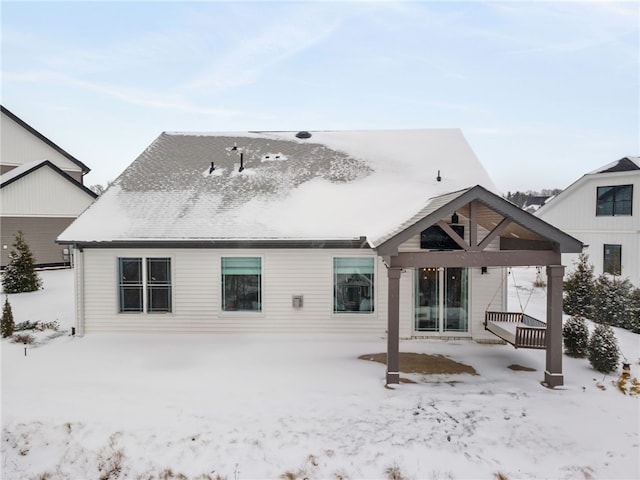 view of snow covered back of property