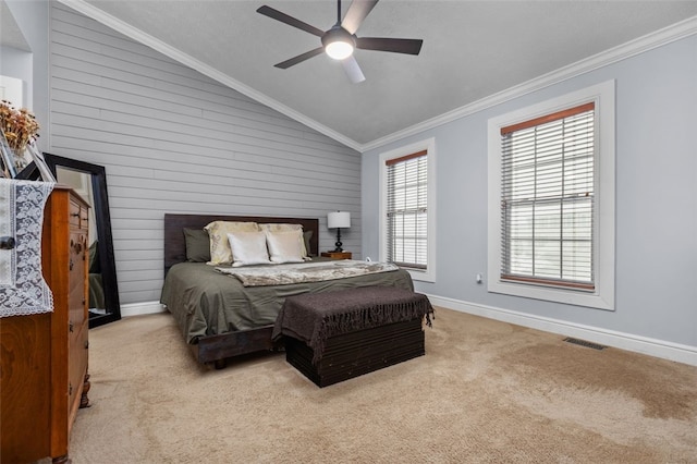 carpeted bedroom with ceiling fan, wooden walls, vaulted ceiling, and ornamental molding