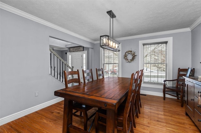 dining room featuring light hardwood / wood-style floors, an inviting chandelier, plenty of natural light, and crown molding