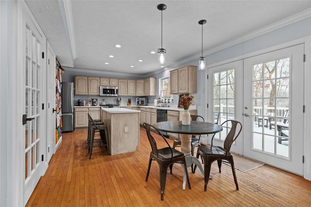 dining room with a textured ceiling, light hardwood / wood-style flooring, crown molding, and french doors