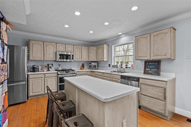 kitchen featuring light brown cabinetry, a breakfast bar area, and appliances with stainless steel finishes