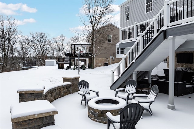 exterior space with a trampoline, an outdoor fire pit, and a wooden deck